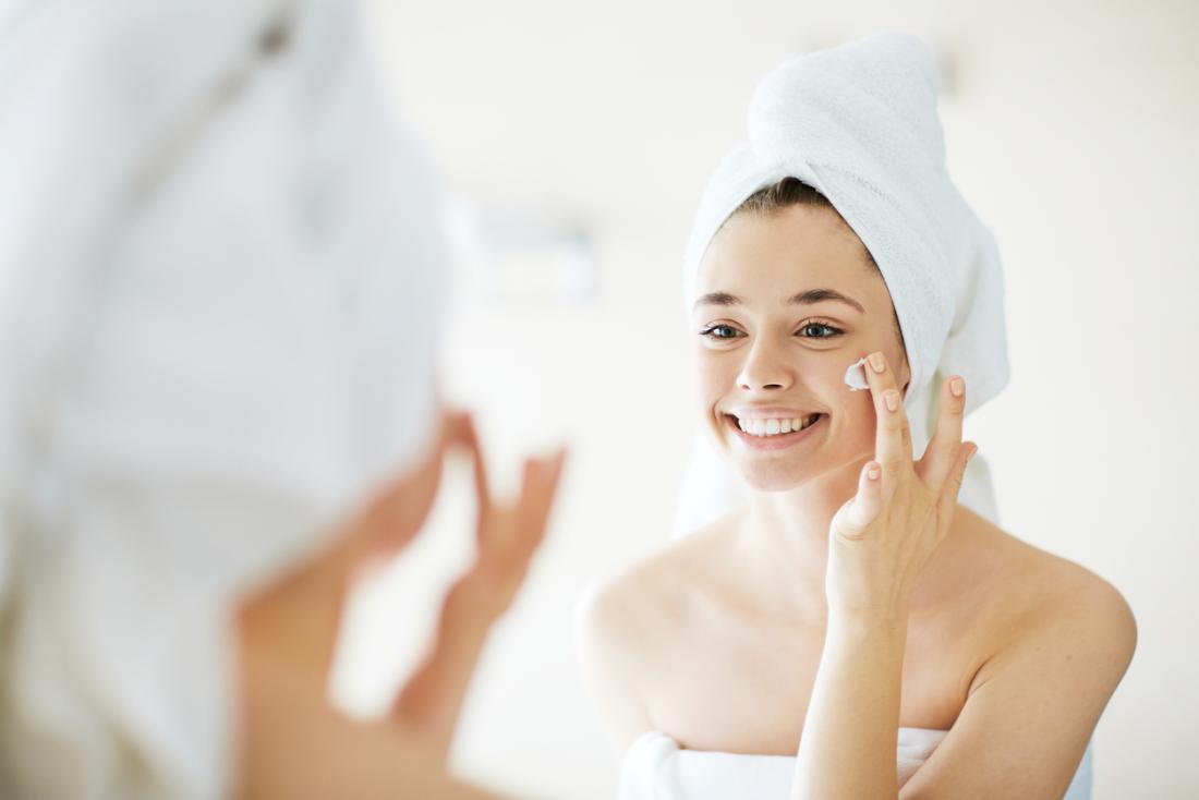 Woman putting on face cream